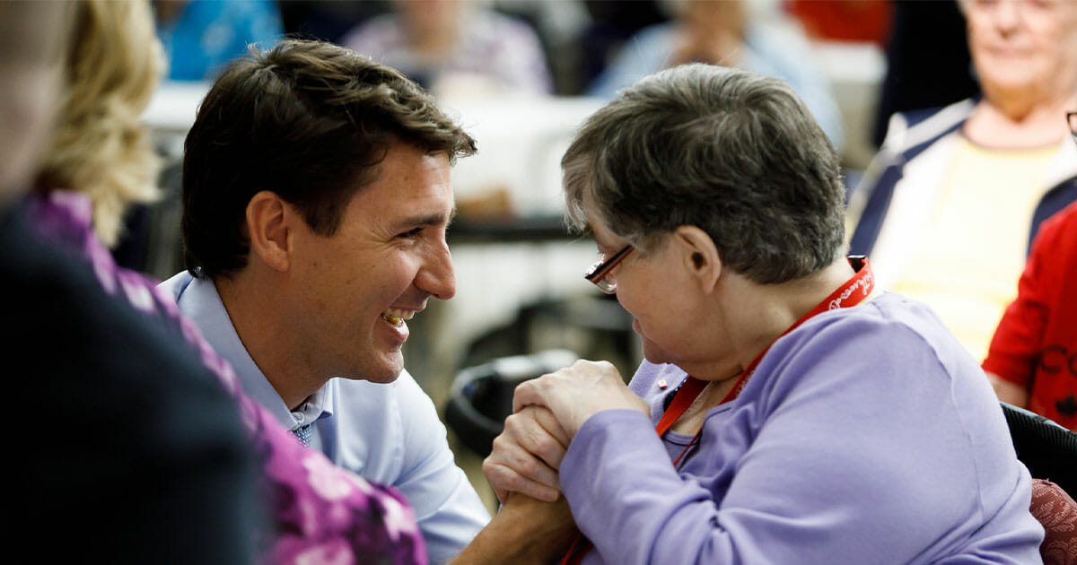 Justin Trudeau having a conversation with a senior